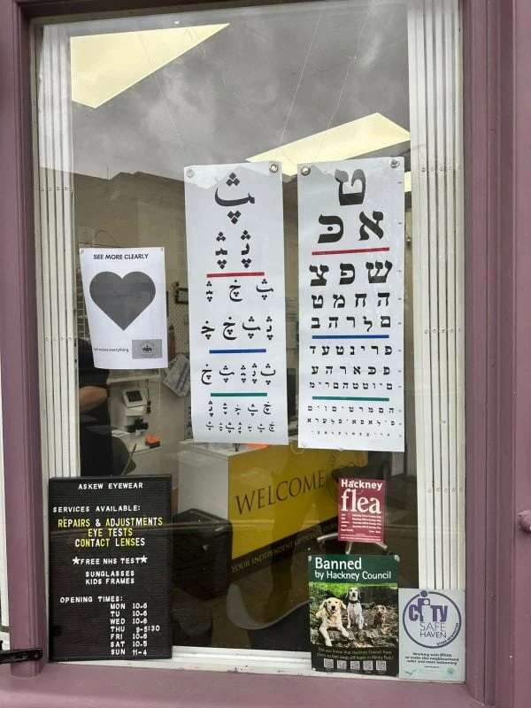 Optical practice window with eye charts in different alphabets and a heart, shortlisted for Best Marketing Campaign at the Optician Awards 2025
