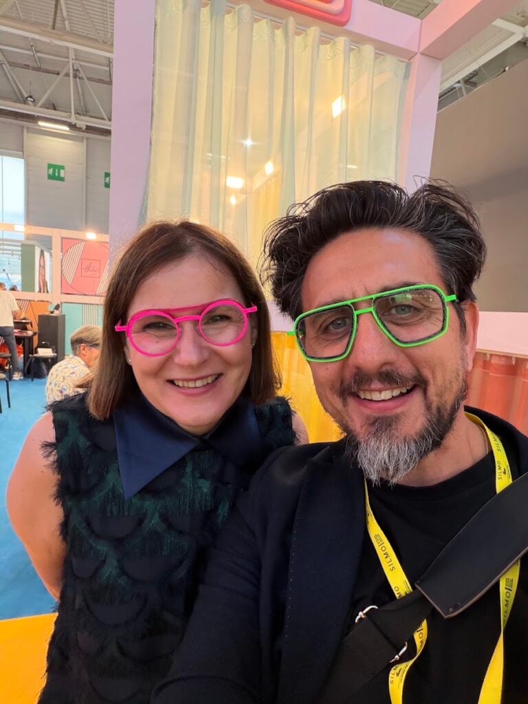 Garry Kousoulou wearing bright green frames at an optical industry event
